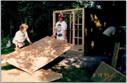 Ernie and his wife lifting a sheet of plywood