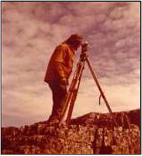 Surveyor with transit on a tripod.