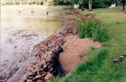 wall of boulders on lake bottom next to lawn