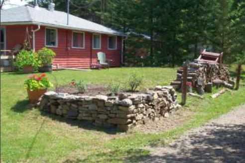 low stone wall at corner of cottage lot