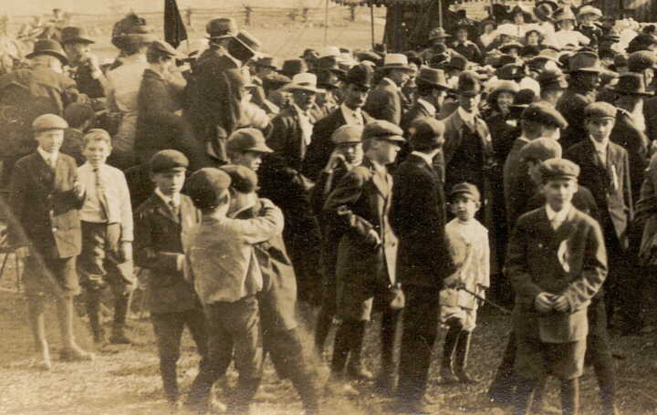 Photograph of some people in crowd around fair or circus tent